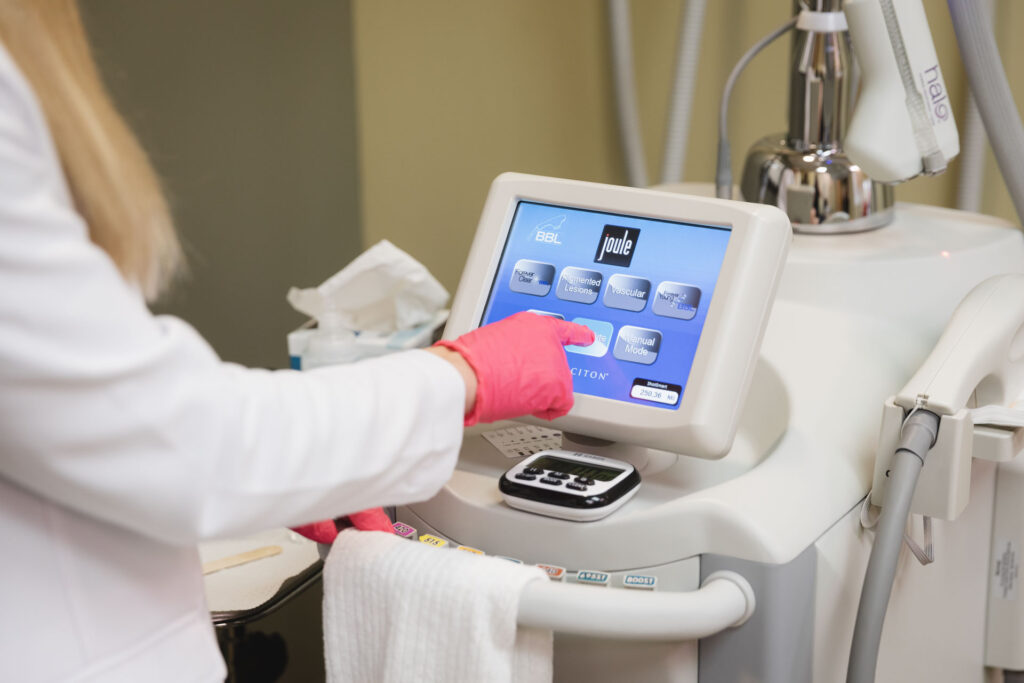 a medical provider wearing pink gloves prepares a skin tightening device with a touchscreen for a patient using semaglutide near Bowling Green, OH