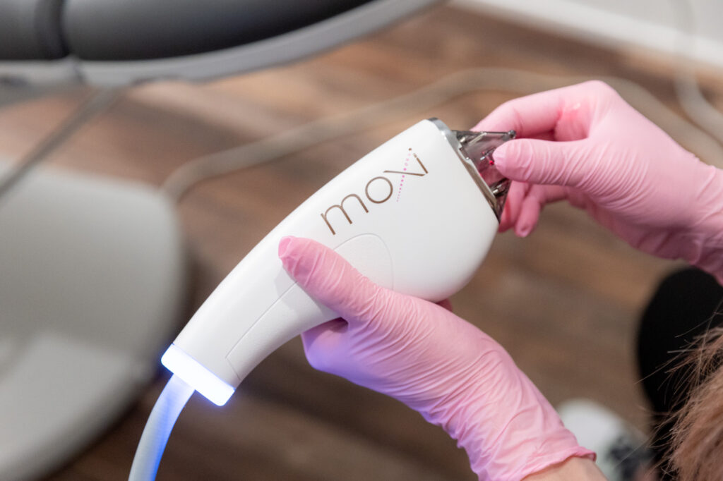 Provider with pink gloves holding a moxi device