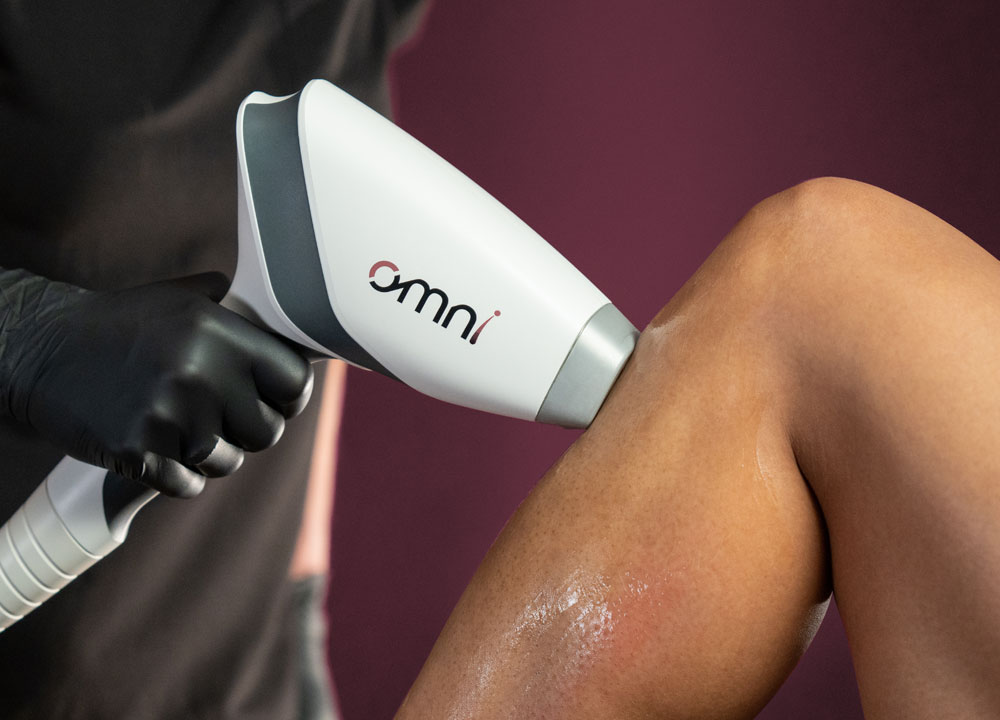 A close up on the Sciton OMNI laser as a Blush Aesthetics provider presses it to a patient's leg. Used for Brazilian laser hair reduction in Columbus, the OMNI safely and effectively removes hair from the labia and perianal.